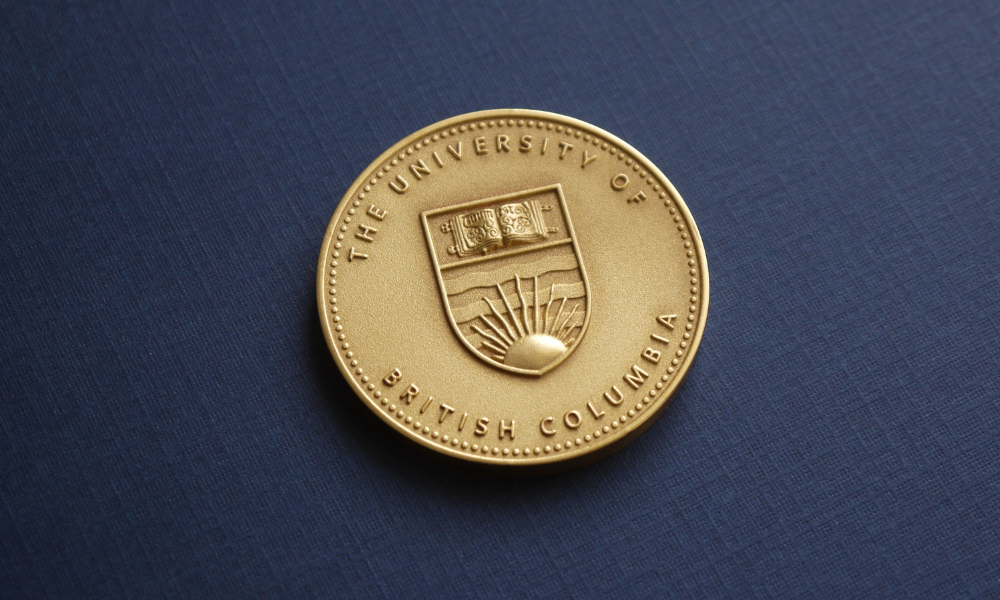 UBC President's Service Award for Excellence medal on blue background