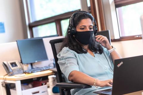 Person wearing mask sitting at computer