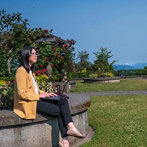 Person sitting in the rose garden looking out to the mountains